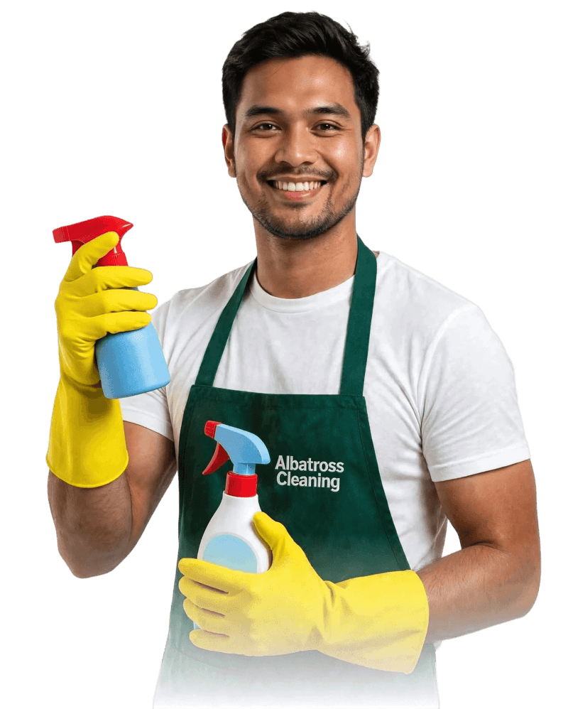 Albatross Cleaning staff member smiling with cleaning supplies.